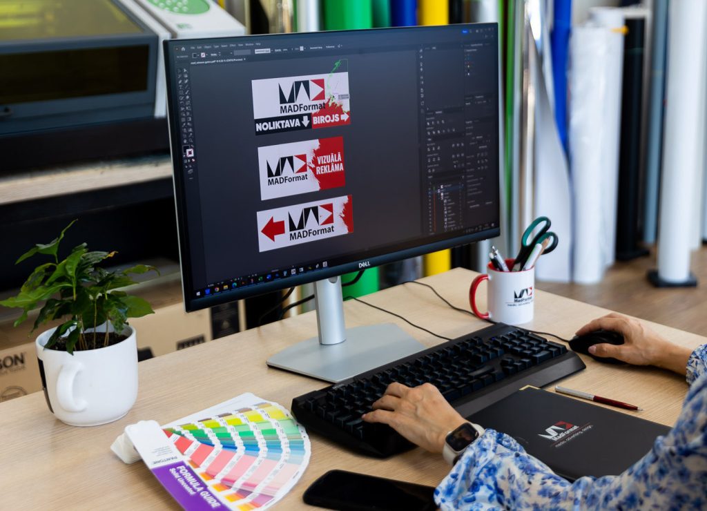 Artwork being prepared on screen beside colour samples